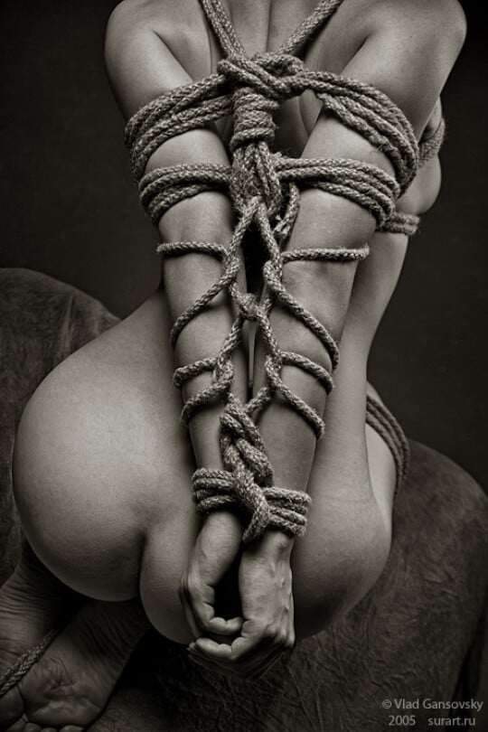 Photo of rear of naked rope bound woman